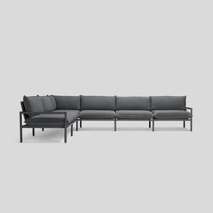 The Terra Sectional is a modern, minimalist L-shaped sofa featuring sleek black metal frame and dark gray cushions, all set against a plain light gray background.
