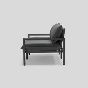 The Terra Loveseat, featuring a minimalist design with a dark gray color scheme, showcases its metal frame and cushioned seat and backrest from the side against a light gray background.