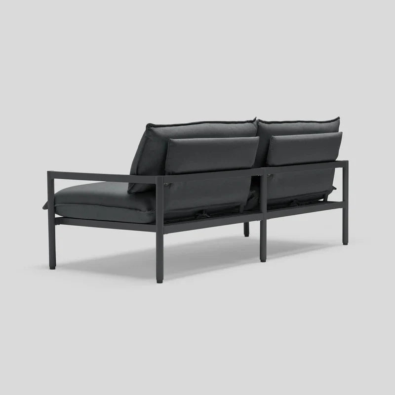 Back view of the Terra Loveseat featuring a modern, minimalist black metal frame with dark cushions. The design highlights clean lines and a sleek silhouette, ideal for contemporary decor.