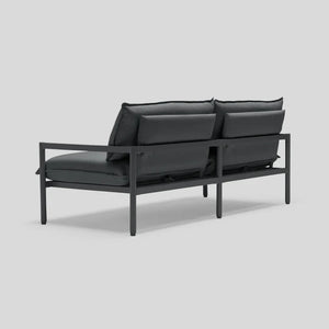 Back view of the Terra Loveseat featuring a modern, minimalist black metal frame with dark cushions. The design highlights clean lines and a sleek silhouette, ideal for contemporary decor.