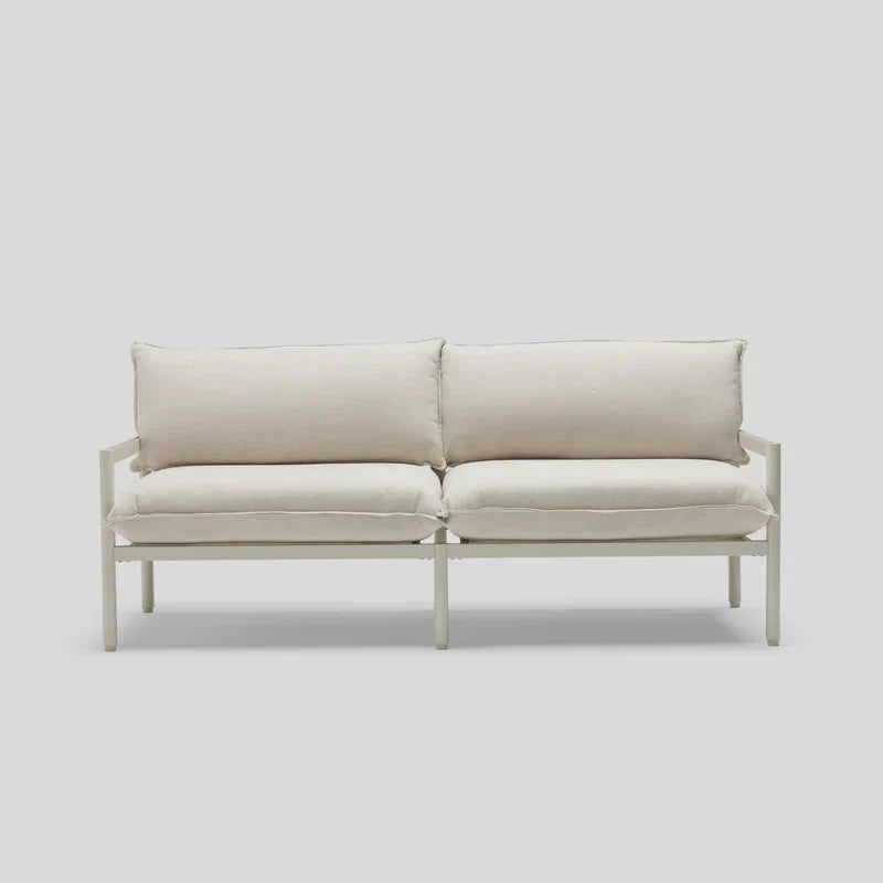 A minimalist Terra Loveseat featuring a white design, metal frame, and plush cushions is set against a light gray background.