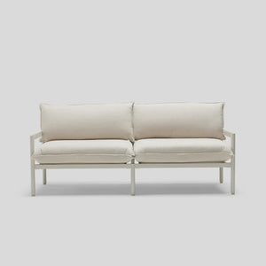 A minimalist Terra Loveseat featuring a white design, metal frame, and plush cushions is set against a light gray background.