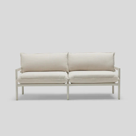 A minimalist Terra Loveseat featuring a white design, metal frame, and plush cushions is set against a light gray background.