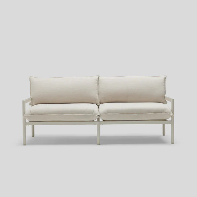 A minimalist Terra Loveseat featuring a white design, metal frame, and plush cushions is set against a light gray background.