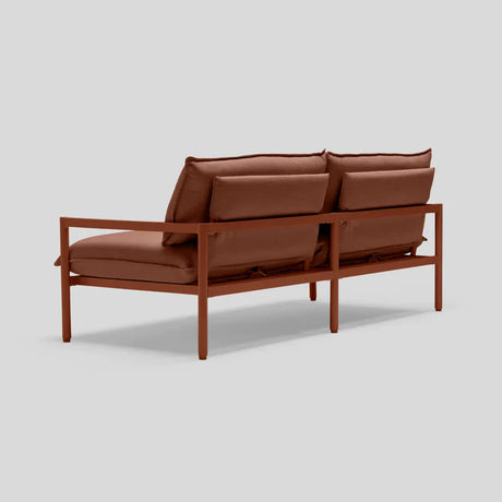 The Terra Loveseat, featuring a contemporary rust-colored metal frame and complementary cushioned backrests and seats, is displayed from a rear angle against a plain gray background.