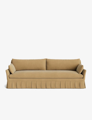 The Portola Pleated Sofa, featuring a beige design with a pleated skirt, comes complete with two long cushions and two cylindrical bolster pillows on each side, all set against a white background.