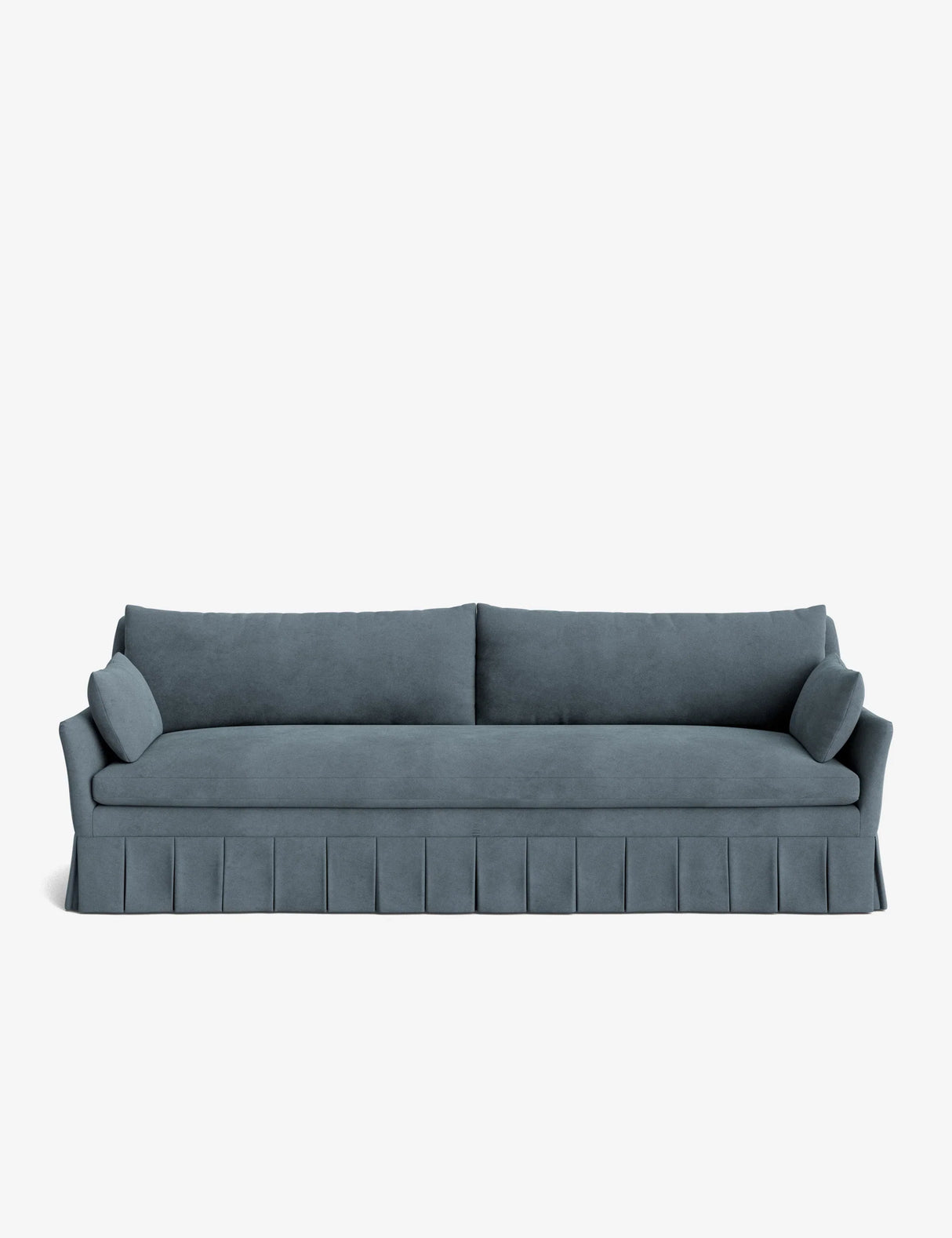 The Portola Pleated Sofa, in a teal velvet finish, showcases pleated skirt detailing, two large back cushions, and two cylindrical side pillows, all set against a plain white background.