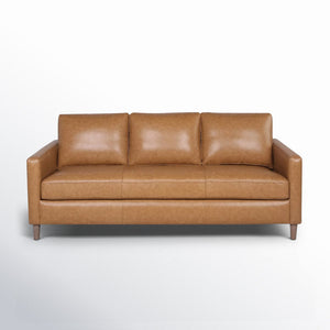 The Portland 80.5" Leather Sofa is a mid-century modern style piece featuring three seat cushions, three back cushions, and straight armrests in brown leather. It is supported by wooden legs and displayed against a plain white background.