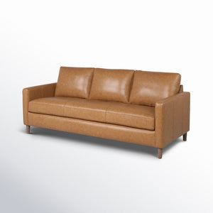 The Portland 80.5" Leather Sofa in tan leather features three cushions and sleek armrests, with wooden legs beautifully set against a light gradient background.