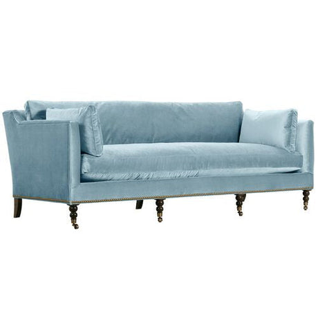 The Margot Velvet Sofa is a light blue piece with plush cushions and dark wooden legs, showcasing a modern design with a high back and armrests.