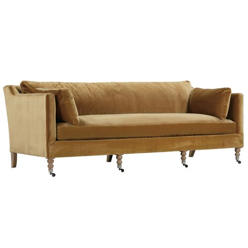 Introducing the Margot Velvet Sofa, a sleek, modern piece in a vibrant mustard-yellow hue. This sofa boasts a straight back and cushioned armrests for ultimate comfort and is elegantly supported by wooden legs with caster wheels. Completing the look are two matching throw pillows included with your purchase.