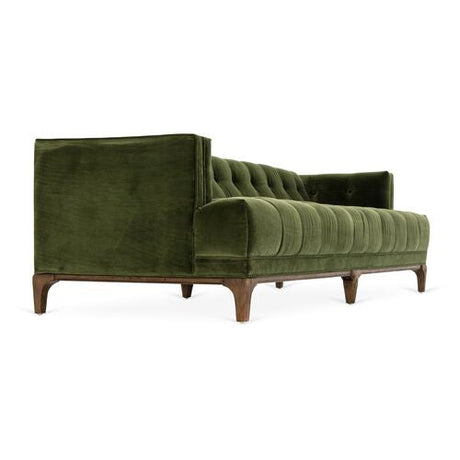 The Caledonia Sofa in Sapphire Olive Velvet is a plush piece with a tufted design and comes with two cushions. It features wooden legs and angled armrests, adding a touch of elegance to the design. The side view showcases its sleek, modern style against a white background.