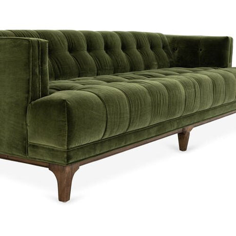 Introducing the Caledonia Sofa in Sapphire Olive Velvet: a green velvet tufted sofa with a low back and wooden legs. The luxurious, plush fabric complements its modern design, accentuated by squared armrests.