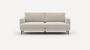 Introducing the Ember Mid-Century Modern 75" Sofa— a contemporary light beige piece showcasing clean lines and a minimalist design. This sofa features two seat cushions and two back cushions, complemented by low armrests and wooden legs, all set against a plain white background.