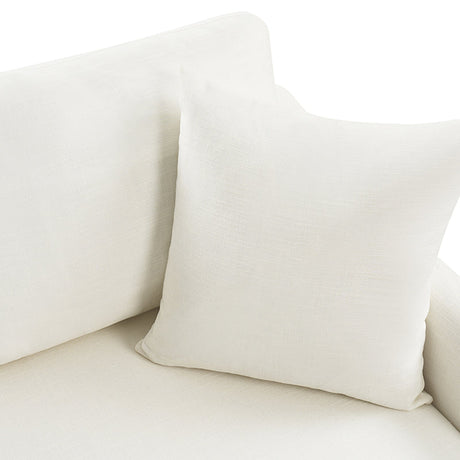 A Torsten Modern Comfortable Sofa with a matching white cushion placed on it. The fabric looks soft and smooth, seamlessly blending with the sofa's upholstered surface. Bright lighting highlights the texture of the textiles.