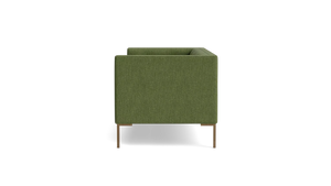 A green Sit Tight 90" Sofa with a minimalist design is displayed in a side view against a black background. It features wooden legs and boasts a boxy shape with clean lines.