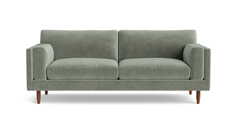 The Skinny Fat 85" Sofa Standard Depth is a stylish, modern sofa in green, featuring two matching cylindrical cushions and wooden legs, set against a plain black background.