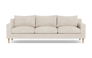 The Sloan Custom 3-Seat 95" Sofa features a beige color with a minimalist design, characterized by its clean lines, three cushions, and wooden legs, photographed against a plain black background.