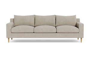 The Sloan Custom 3-Seat 95" Sofa, featuring a beige upholstery, square cushions, and wooden legs, is set against a plain black background. Its simple and modern design includes a straight back with armrests aligned at the same height as the back cushions.