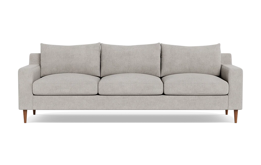 The Sloan Custom 3-Seat 95" Sofa features a modern design with a light gray finish, encompassing three seat cushions and three back cushions. Its clean, simple lines and wooden legs contribute to its minimalist and stylish look. The sofa is presented against a plain black background.