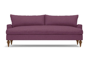 The Saxon Sofa is a modern piece in purple, featuring wooden legs and a sleek, minimalist design with a cushioned backrest. Its smooth fabric texture makes it an ideal choice for a contemporary living room setting.