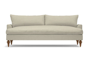 The Saxon Sofa is a minimalist, beige three-seater featuring two large back cushions and wooden legs. It rests on a white background and boasts a plush, cushioned seating area.