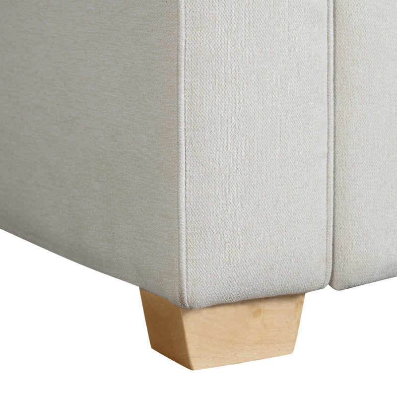 Close-up of the corner of a Serta Monroe Full Size Convertible Sofa with a wooden leg, highlighting the texture and stitching details of the light-colored upholstery.