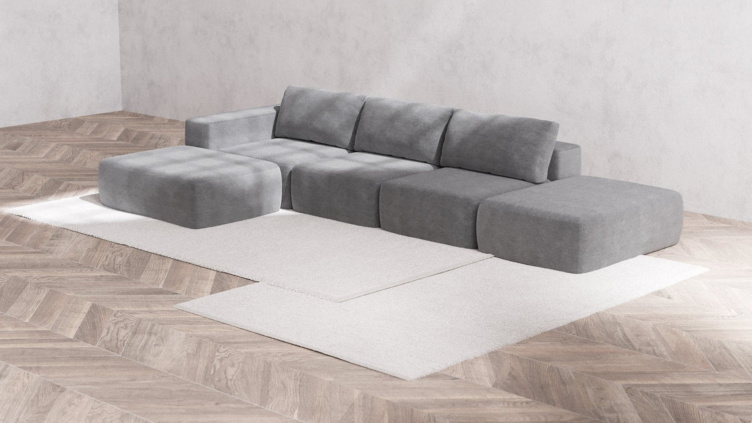A modern minimalist living room showcases the Modular 3-Seater Open-End Chaise Sectional | Boucle in Aspen, paired with a matching ottoman on a light beige area rug. The room is accentuated by parquet flooring and textured light gray walls, which enhance the sleek and contemporary ambiance.