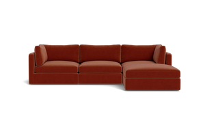 A contemporary Tatum Modular 3 Seat Chaise 106" Sectional showcasing clean lines, adorned with deep orange cushions, set against a simple black backdrop, and offering plush seating.