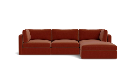 A contemporary Tatum Modular 3 Seat Chaise 106" Sectional showcasing clean lines, adorned with deep orange cushions, set against a simple black backdrop, and offering plush seating.