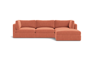 The Tatum Modular 3 Seat Chaise 106" Sectional is a contemporary, modular sofa with a right-hand chaise, featuring upholstery in warm terracotta fabric and set against a solid black background.