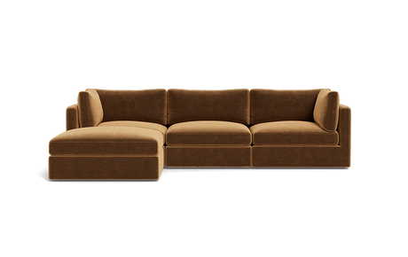 The Tatum Modular 3 Seat Chaise Sectional is a brown sofa with three seat cushions and an extended chaise lounge on the left. It showcases plush back cushions and a modern design, set against a plain black background.