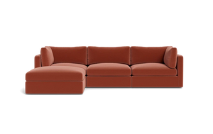 A sleek Tatum Modular 3 Seat Chaise Sectional in a rust hue, featuring a left-side chaise and showcased against a black backdrop. This sectional is designed with plush cushions and embodies a streamlined, minimalist aesthetic.