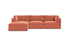 The Tatum Modular 3 Seat Chaise Sectional is a spacious, contemporary sofa featuring a chaise lounge. It's upholstered in an inviting, earthy orange fabric with clean lines and plush cushions, set against a simple black background.