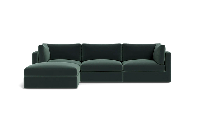 The Tatum Modular 3 Seat Chaise Sectional, featuring sleek cushions and a left-sided chaise in dark green, is set against a plain black background.