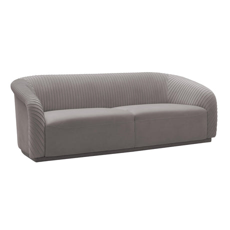 The Yara Pleated Velvet Sofa by Inspire Me! Home Decor is a contemporary piece featuring a rounded backrest and armrests. It is upholstered in modern gray velvet with a vertically stitched pattern, making it a sleek addition that complements various interior styles.
