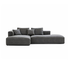 Introducing The 5th Open 116" Left Facing Sectional, a sleek dark gray sofa embodying modern minimalism. Its design includes two spacious central cushions complemented by smaller end cushions, offering a cozy and welcoming seating experience.