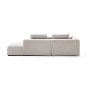 The 5th Open 116" Left Facing Sectional, a minimalist beige sofa viewed from the back, boasts three back cushions and a clean, modern design with straight lines, set against a plain white background.
