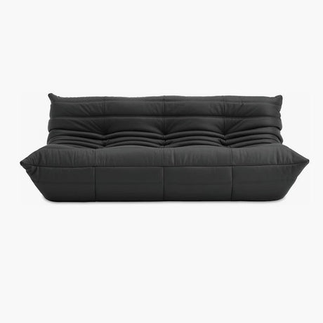 The Togo Sofa in Opera Leather boasts a sleek design in black leather, featuring a tufted pattern with deep cushions and an elegant modern aesthetic set against a plain white background.