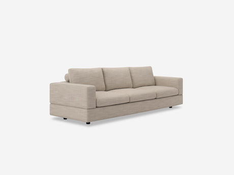 The Stage Track Sofa, a beige, modern three-seater with square arms and cushioned seats, is set against a plain white background. Its sleek design showcases simple, clean lines.