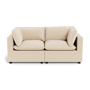 The Kova Pillow Cushion Sofa 86" is a modern beige two-seater with plush seat and back cushions, plus two matching side pillows, shown from the front against a plain background.