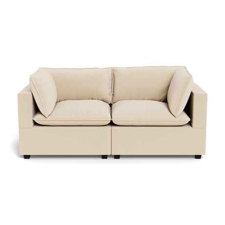 The Kova Pillow Cushion Sofa 86" is a modern beige two-seater with plush seat and back cushions, plus two matching side pillows, shown from the front against a plain background.