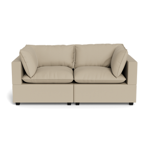 The Kova Pillow Cushion Sofa 86" is a beige, modern two-seater with square arms, plush seat and back cushions, plus two matching side pillows, displayed against a plain black background.