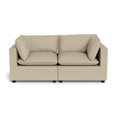 The Kova Pillow Cushion Sofa 86" is a beige, modern two-seater with square arms, plush seat and back cushions, plus two matching side pillows, displayed against a plain black background.
