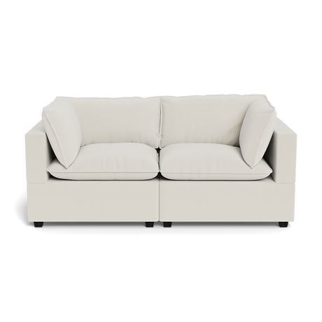 The Kova Pillow Cushion Sofa 86" is a modern, light beige two-seater with wide armrests, plush seat cushions, and two matching back cushions, shown from the front against a plain background.