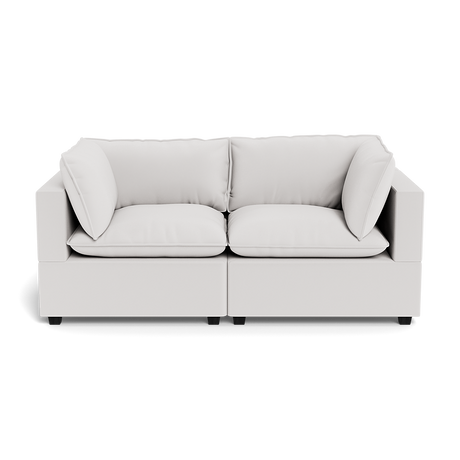 The Kova Pillow Cushion Sofa 86" is a modern, light gray two-seater with square arms and four matching cushions, shown from the front against a black background.