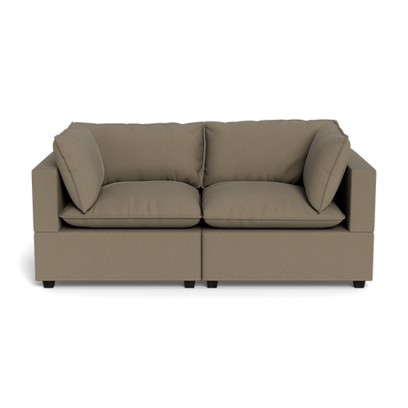 The Kova Pillow Cushion Sofa 86" features a modern, boxy design with light brown upholstery, two seat cushions, two back cushions, and two matching side pillows—displayed against a plain black background.