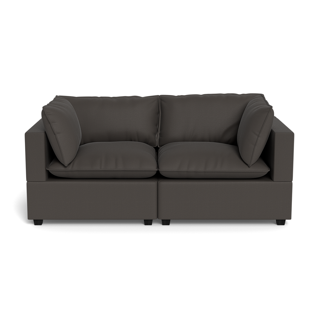 The Kova Pillow Cushion Sofa 86" is a modern, dark gray two-seater with clean lines and four matching cushions, shown from the front against a black background.