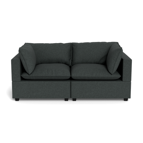 The Kova Pillow Cushion Sofa 86" is a modern dark grey two-seater with square arms and four matching cushions, displayed against a plain black background.