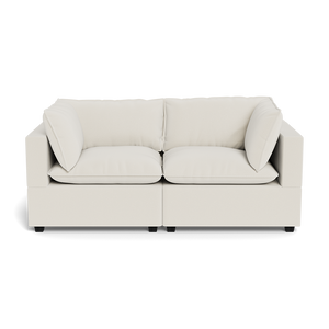 The Kova Pillow Cushion Sofa 86" is a modern, off-white two-seater with square arms, plush seat cushions, and matching back and side pillows, shown from the front against a plain background.
